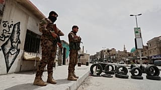 تقف قوات الأمن الحكومية السورية حراسة عند نقطة التفتيش الخاصة بهم عند أحد مداخل ضاحية جرمانا الجنوبية، دمشق، سوريا، 30.04.2025