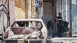 مسلحون درزيون يقفون بالقرب من نقطة تفتيش ، بعد يوم من الاشتباكات بين أفراد الأقلية الدرزية والمقاتلين الموالين للحكومة في جرمانا 2025