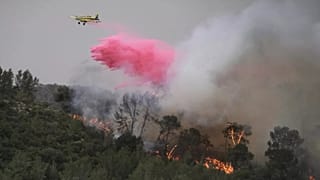 A plane uses a fire retardant to extinguish a fire burning in a forest near Jerusalem, 30 April 2025.