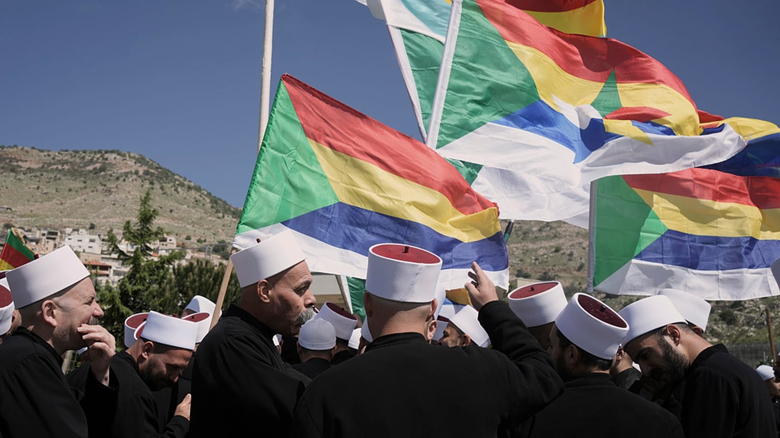 Μέλη της κοινότητας των Δρούζων του Ισραήλ στέκονται κοντά στα σύνορα, περιμένοντας τα λεωφορεία που μεταφέρουν Δρούζους κληρικούς από τη Συρία για να περάσουν τα σύνορα στην πόλη Majdal Shams, 25 Απριλίου 2025.