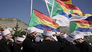 أعضاء من الطائفة الدرزية في إسرائيل يقفون بالقرب من الحدود، بانتظار الحافلات التي تقل رجال دين دروز من سوريا لعبور الحدود إلى بلدة مجدل شمس،  25 أبريل 2025