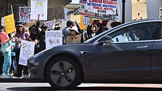 Tesla halad el egy Musk-ellenes tüntetés előtt Kaliforniában