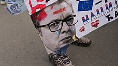 Eine Frau hält ein Plakat, das den serbischen Präsidenten Aleksandar Vucic in Novi Sad, Serbien, am Freitag, den 25. April 2025, zeigt