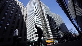 A pedestrian is silhouetted against a high rise at 160 Water Street in Manhattan's financial district, 11 April 2023.