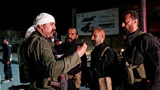 مسلح درزي يتحدث مع قوات الأمن السورية بعد التوصل إلى اتفاق للانتشار في محيط جرمانا جنوب دمشق، الجمعة 2 مايو 2025.