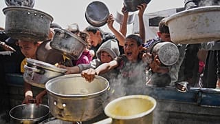 Палестинские дети пытаются получить пожертвованную еду на общественной кухне в Хан-Юнисе, сектор Газа, суббота, 3 мая 2025 года.