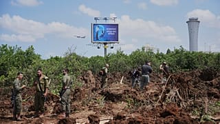 Ισραηλινές δυνάμεις ασφαλείας επιθεωρούν το σημείο όπου ένας πύραυλος που εκτοξεύθηκε από τους Χούθι έπληξε την περιοχή κοντά στο αεροδρόμιο Μπεν Γκουριόν