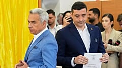 Calin Georgescu, Mogosoaia'da tekrarlanan cumhurbaşkanlığı seçimlerinin ilk turunda oylarını kullanırken cumhurbaşkanı adayı George Simion'un yanında duruyor, 4 Mayıs 2025