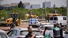 Israeli security forces inspect the site where a missile fired by Yemen's Houthi rebels landed in the area of Ben Gurion International Airport near Tel Aviv, 4 May 2025
