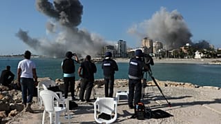 Журналисты снимают, как дым поднимается от зданий, подвергшихся израильским авиаударам в Тире, южный Ливан, 28 октября 2024 года. 