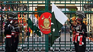 Pakistan's Rangers soldiers and Indian Border Security Forces soldiers lower their flags during a daily closing ceremony at the Wagah, 3 May 2025.