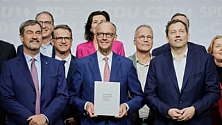 CSU leader Markus Soeder, CDU leader Friedrich Merz and SPD leader Lars Klingbeil stand with the new ministers after signing a coalition treaty in Berlin, 5 May, 2025