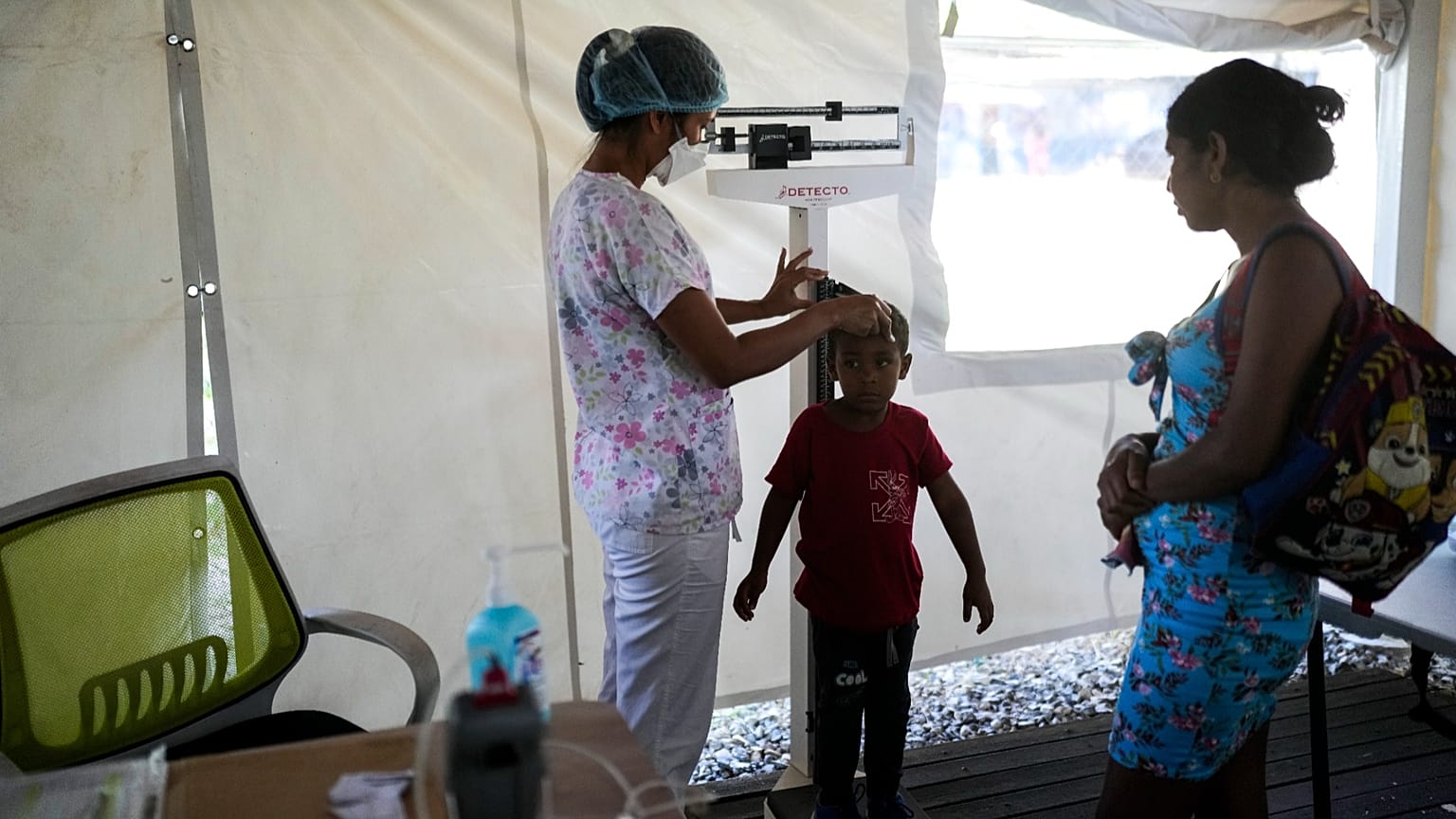 A Doctors without Borders staff measures a child's height at the organizations medical clinic in Putucual, Venezuela, Wednesday, Jan. 10, 2024.