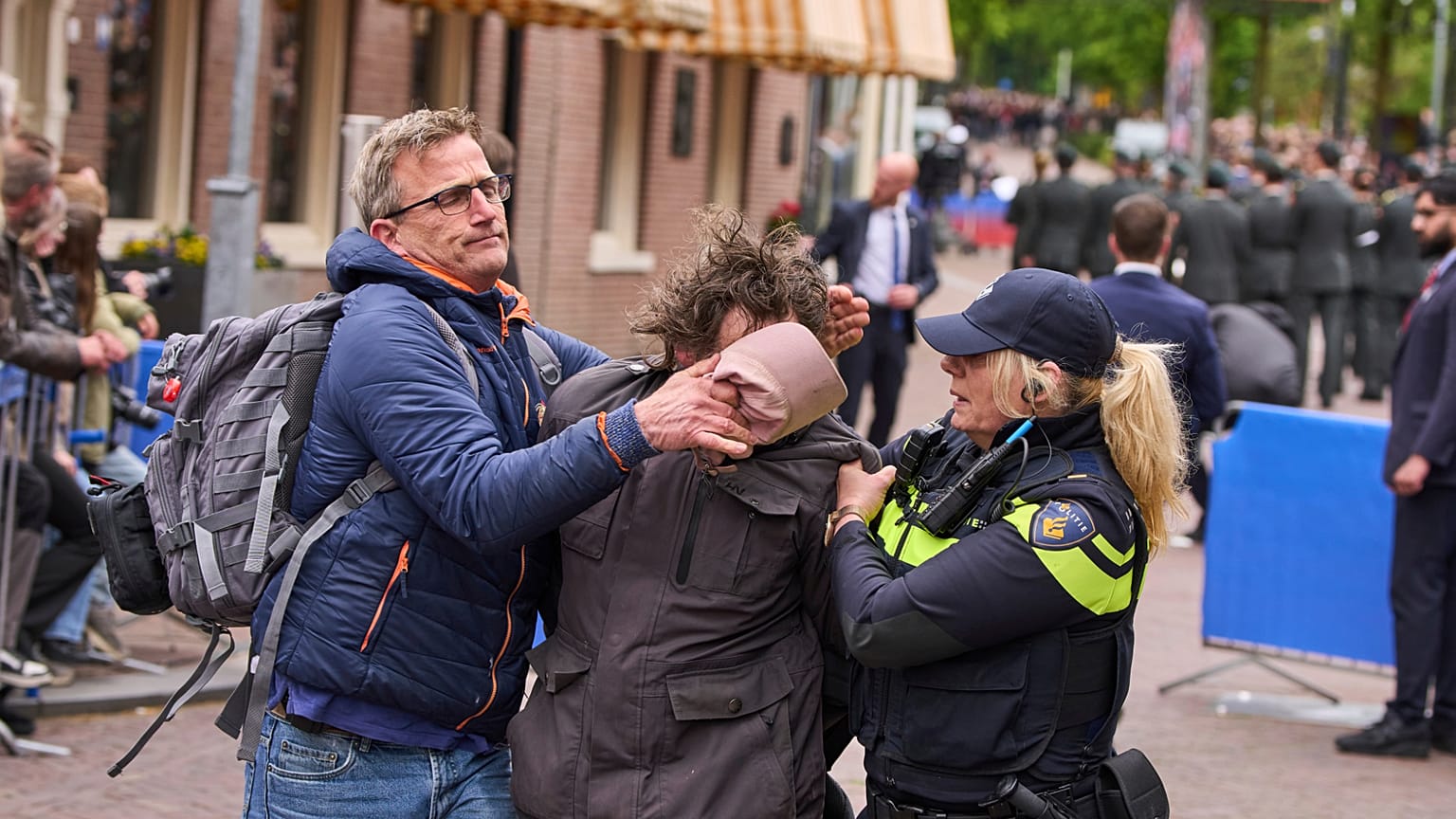 Niederländische Polizei bringt einen pro-palästinensischen Demonstranten zum Schweigen, der Parolen ruft, während sich Dutzende von Veteranen des Zweiten Weltkriegs am 05.05.2025 in Wageningen zu den Feierlichkeiten zum Befreiungstag versammelten