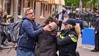 Niederländische Polizei bringt einen pro-palästinensischen Demonstranten zum Schweigen, der Parolen ruft, während sich Dutzende von Veteranen des Zweiten Weltkriegs am 05.05.2025 in Wageningen zu den Feierlichkeiten zum Befreiungstag versammelten
