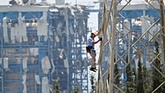 Ein Elektrizitätsarbeiter klettert auf einen Strommast neben dem Kraftwerk Mari, 12. Juli 2011