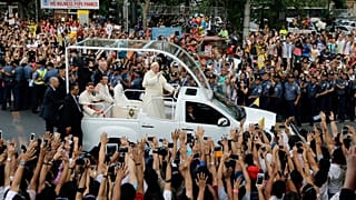 O Papa Francisco acena aos espectadores a partir do seu papamóvel enquanto a sua comitiva passa por Manila, 16 de janeiro de 2015