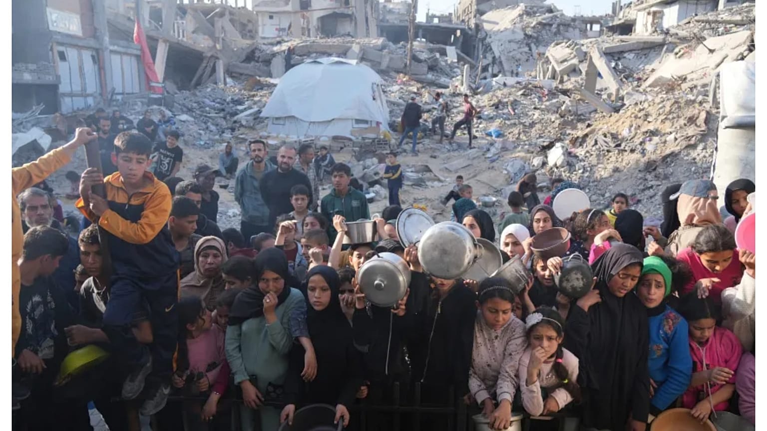 فلسطينيون ينتظرون معونات الطعام في بيت لاهيا بشمال قطاع غزة. 16 مارس 2025.