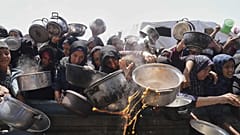فلسطينيون يجهدون للحصول على حصّة طعام من مطبخ جماعيّ في خان يونس جنوب قطاع غزة - 5 أيار / مايو 2025 
