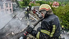 Rettungskräfte löschen ein Feuer in einem Gebäude, das durch einen russischen Streik in Charkiw schwer beschädigt wurde, 6. Mai 2025 