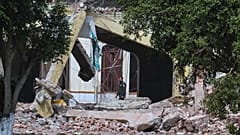 A security guard walks through rubble of a damaged building after a suspected Indian missile attack in Muridke, 7 May, 2025