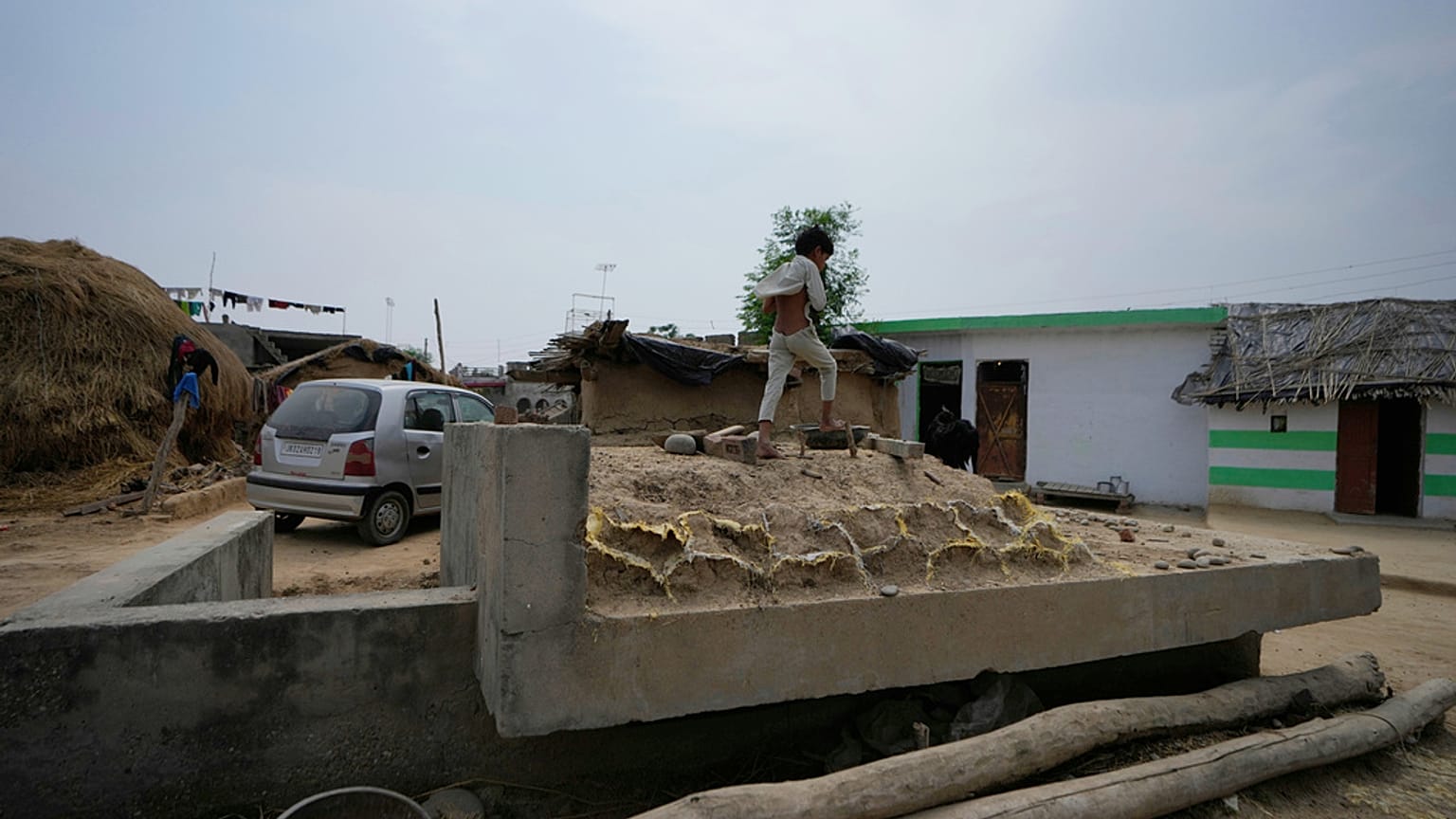 Criança indiana caminha sobre um bunker perto da fronteira internacional entre a Índia e o Paquistão na aldeia agrícola de Jora, em Ranbir Singh Pura, a cerca de 35 quilómetro