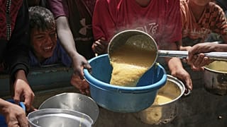 Filistinli çocuklar, Gazze Şeridi'nin güneyindeki Han Yunus'ta bir topluluk mutfağında dağıtılan yardımlık yiyeceklere ulaşmakta güçlük çekiyor, 24 Nisan 2025