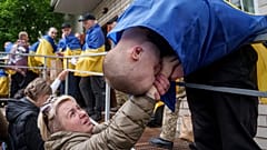 Egy ukrán katona kezet csókol egy nőnek, miután hazatért a fogságból az Oroszország és Ukrajna közötti hadifogolycsere során, 2025. május 6-án.