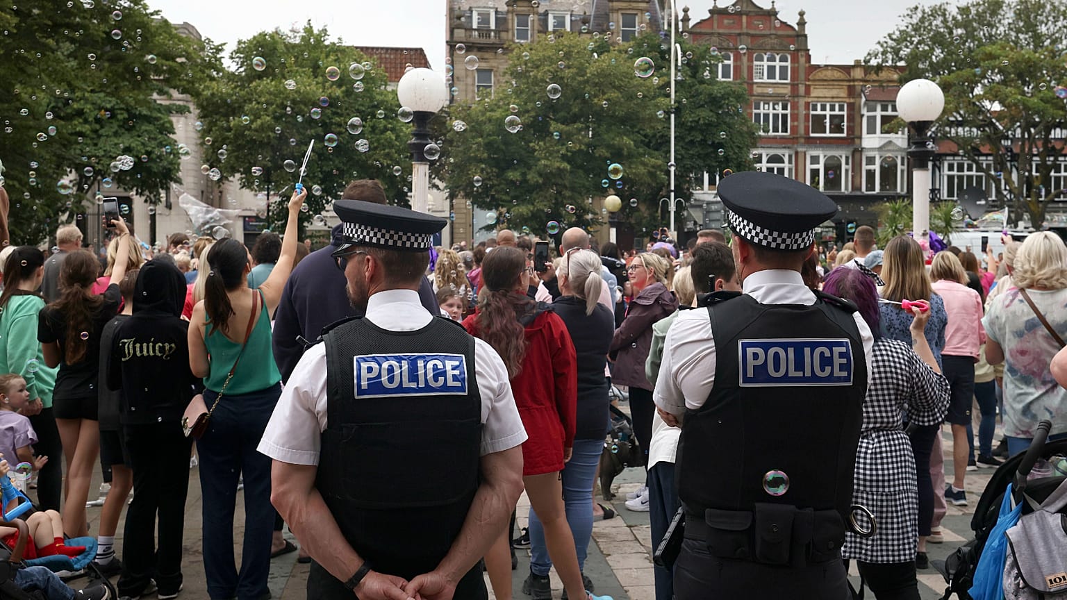Agentes da polícia observam a multidão no exterior da Câmara Municipal de Southport, 5 de agosto de 2024 