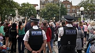 Agentes da polícia observam a multidão no exterior da Câmara Municipal de Southport, 5 de agosto de 2024 