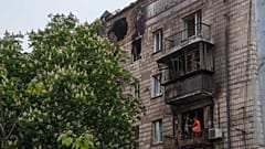 Ein städtischer Arbeiter räumt die Trümmer von einem Balkon eines Wohngebäudes, das nach einem russischen Streik in Kiew beschädigt wurde, 7. Mai 2025