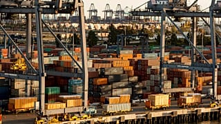 In this Wednesday, Jan. 14, 2015 file photo, shipping containers are stacked up waiting for truck transport at the Port of Los Angeles.