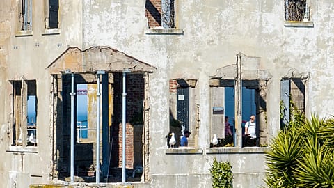 Un visiteur regarde la maison du gardien à l'île d'Alcatraz, le lundi 5 mai 2025, à San Francisco