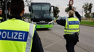  Deutsche Polizeibeamte halten einen Bus an der Grenze zwischen Deutschland und Frankreich in Kehl, Deutschland, an. (Symbolbild)