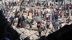 فلسطينيون يجمعون أمتعتهم من مدرسة يستخدمها النازحون كمأوى لهم بعد أن تعرضت للقصف مرتين من قبل الجيش الإسرائيلي في البريج، 7 مايو/أيار 2025