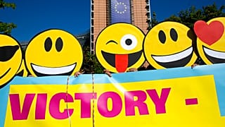 Des membres d'une flashmob portent des masques Emoji lors d'une manifestation devant le siège de l'UE à Bruxelles le mardi 30 août 2016.