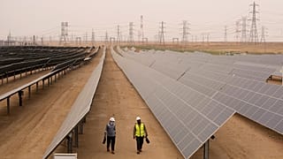 Engineers walk next to solar panels at Benban Solar Park in Aswan, 19 October, 2022