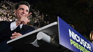 Кандидат в президенты Никусор Дан жестикулирует, обращаясь к сторонникам после закрытия избирательных участков на первом туре повторных президентских выборов в Бухаресте.