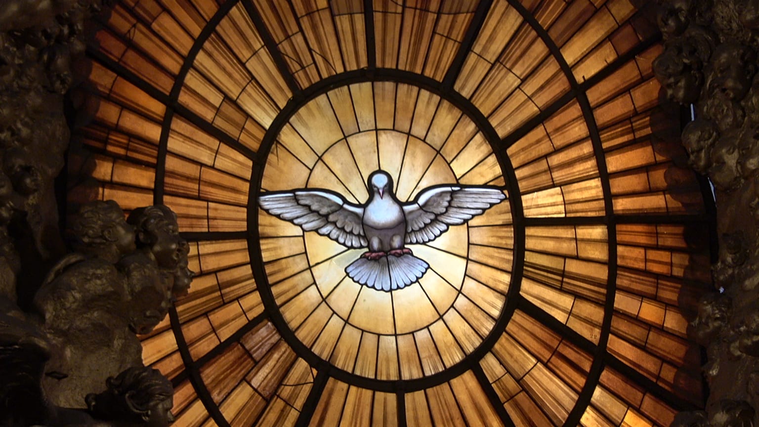 Una vidriera del Espíritu Santo corona el espectacular telón de fondo del trono papal en la Basílica de San Pedro del Vaticano.