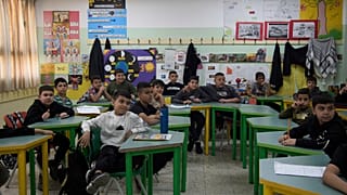 يجلس الطلاب على مقاعدهم في مدرسة الأونروا للبنين التي تديرها وكالة الأمم المتحدة لإغاثة وتشغيل اللاجئين الفلسطينيين في مخيم شعفاط للاجئين في القدس الشرقية، 29 أبريل 2025