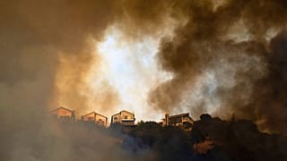 Smoke rises above homes as a grass fire burns near Interstate 580 in Oakland, California, 18 October 2024.