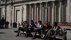 İnsanlar Londra'da The City olarak bilinen finans bölgesindeki İngiltere Merkez Bankası'nın önündeki banklarda oturuyor. 9 Nisan 2025.