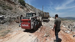 Munkások lezárnak egy krátert az izraeli légicsapásokat követően, amelyek hegycsúcsokat céloztak Nabatieh város közelében, Dél-Libanonban, 2025. május 8.
