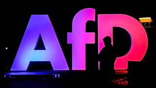 A man stands in front of the logo at the AfD party headquarters in Berlin, 23 February, 2025