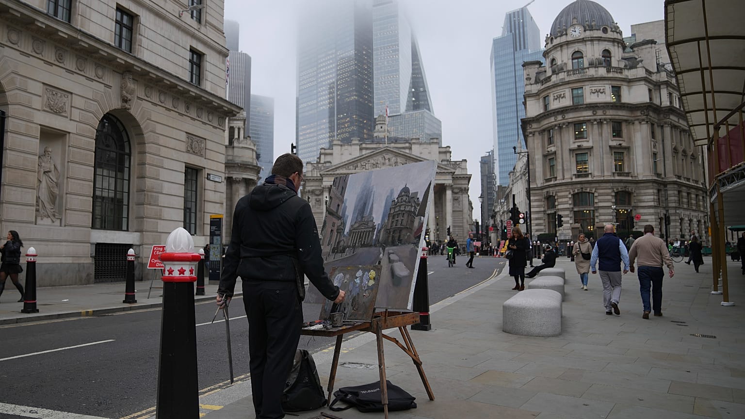 A man paints in front of the Bank of England, at the financial district, in London, Wednesday, Nov. 6, 2024.