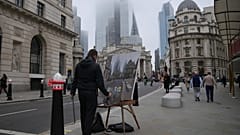 A man paints in front of the Bank of England, at the financial district, in London, Wednesday, Nov. 6, 2024.