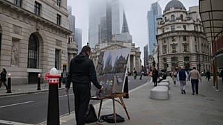 A man paints in front of the Bank of England, at the financial district, in London, Wednesday, Nov. 6, 2024.