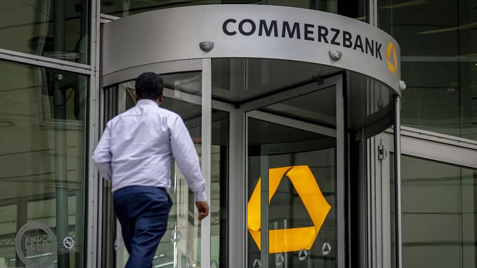 A man walks towards the entrance of the headquarters of the Commerzbank in Frankfurt, Germany, Tuesday, Sept. 24, 2024.