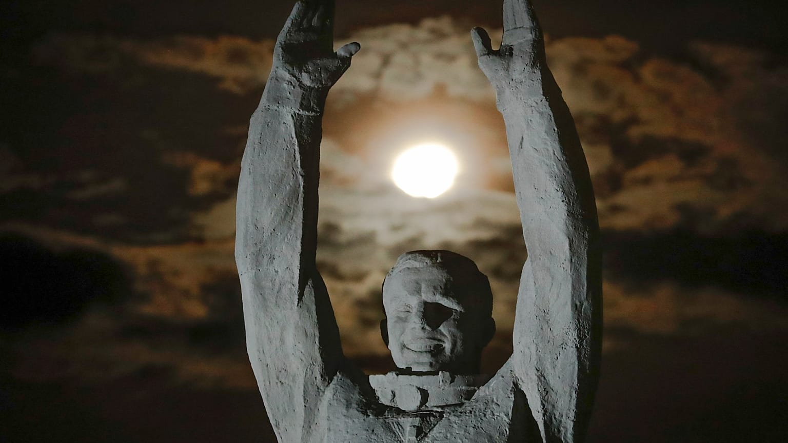 A Hold lenyugszik az első űrhajós, Jurij Gagarin szobra felett az oroszok által bérelt Bajkonur űrrepülőtéren, Kazahsztánban, 2016. november 12-én.