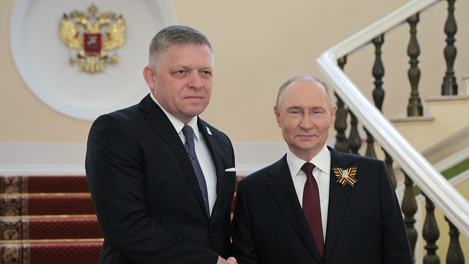 O primeiro-ministro da Eslováquia, Robert Fico, e o presidente russo, Vladimir Putin, apertam as mãos durante o seu encontro antes dos desfiles do Dia da Vitória em Moscovo, Rússia, sexta-feira, 9 de maio de 2025